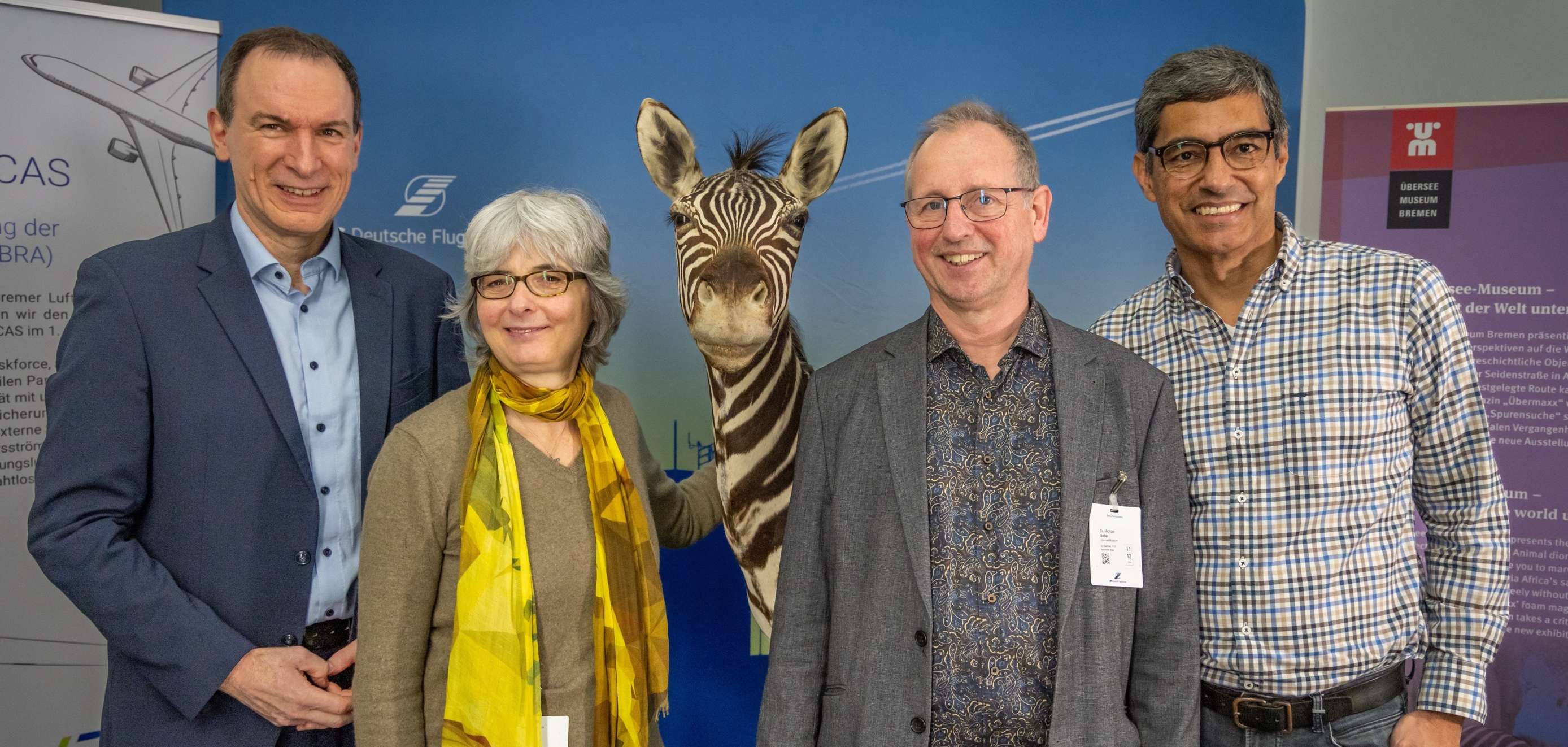 Feierliche Übergabe des Zebras vom Übersee-Museum (v.l.n.r.: Niederlassungsleiter Andre Biestmann, Präparatorin Ruth Nüß, Dr. Michael Stiller, Leiter Naturkundeabteilung des Übersee-Museums, Hansjörg Trost, Leiter Luftraum und Verfahren