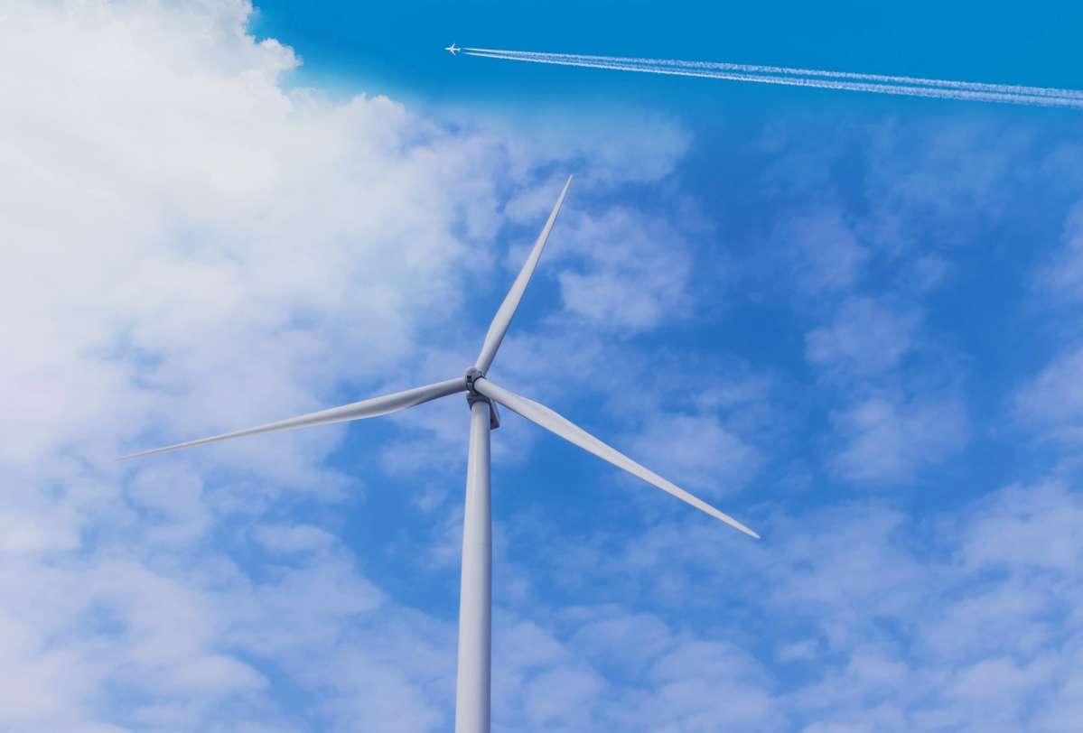 wind turbine with aircraft passing in the sky wind turbine with aircraft passing in the sky