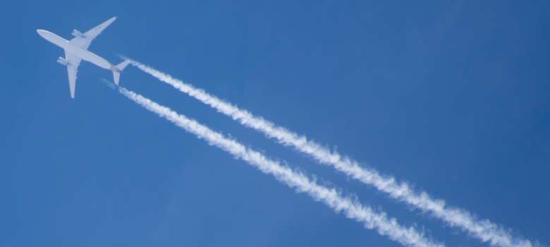 Flugzeug mit Kondensstreifen im Reiseflug