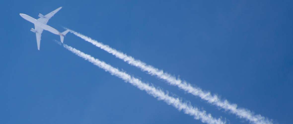 Flugzeug mit Kondensstreifen im Reiseflug Flugzeug mit Kondensstreifen im Reiseflug