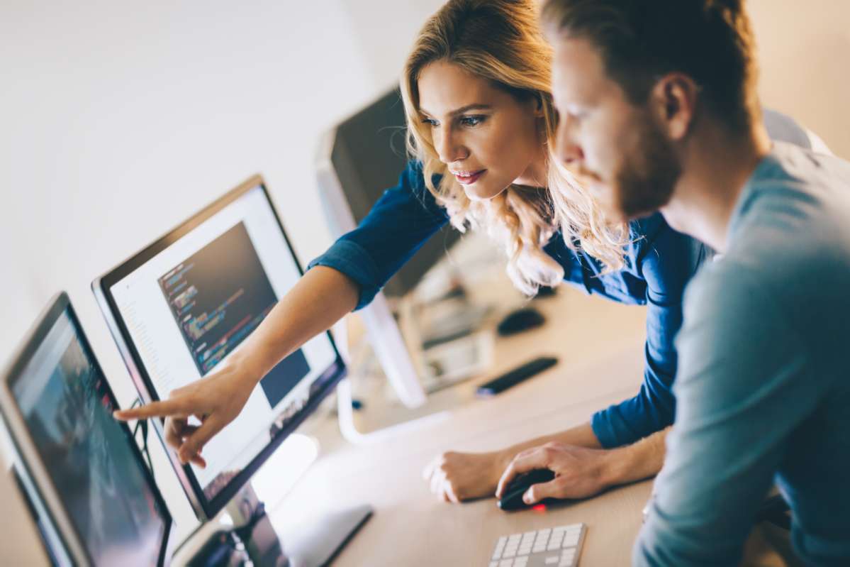 two people in front of a monitor two people in front of a monitor